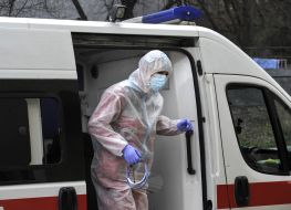 Медпрацівник біля автомобіля швидкої допомоги