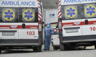 Медпрацівник біля автомобіля швидкої допомоги