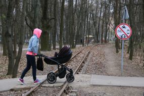 Woman with a stroller walks in the park