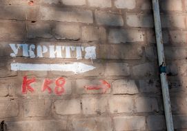 The inscription "Shelter" and a pointing arrow on the wall of a residential building in Kharkiv