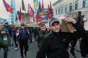 Участники марша несут деревянный крест