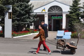Girl carries scrap metal in a wheelbarrow