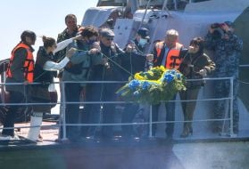Alexander Starukh and servicemen lower the wreath on the water