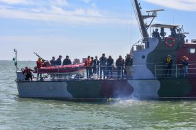 Alexander Starukh and servicemen lower the wreath on the water