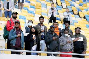 Fans in the stands sing the anthem