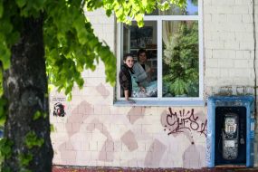 Жінки стоять біля вікна