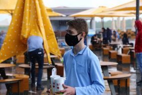 Young man with drinks in paper cups in Kiev