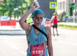 The participant of the charity race "Let's run together" is refreshed with water