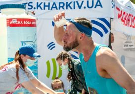 The participant of the charity race "Let's run together" is refreshed with water