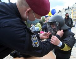 The boy tries on a protective helmet