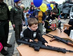 The boy examines the machine gun
