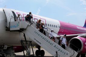 Пассажиры выходят из самолета