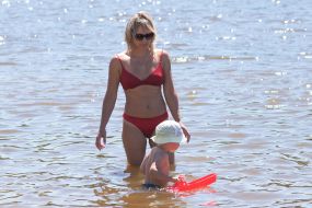 Жінка з дитиною купаються в річці