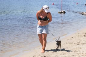 Жінка із собакою на пляжі