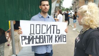 The activist holds a poster with the inscription "Enough to destroy Kiev"