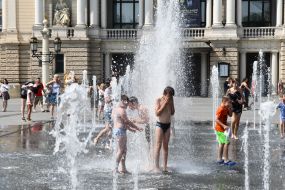 Дети играют в фонтане