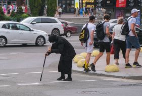 An elderly woman begs for alms