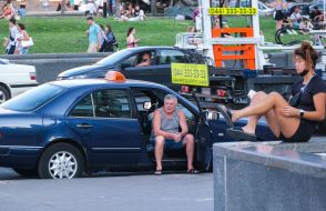 Водій таксі відпочиває на пасажирському сидінні автомобіля