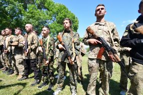 Participants of the training camp "With a golden lion on his sleeve" stand with models of weapons