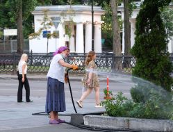 Woman watering a flower bed