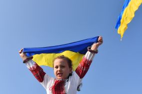 Девочка в вышиванке держит флаг Украины