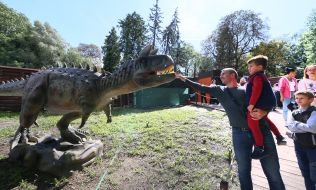 A man strokes a dinosaur