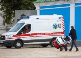 A man drives children's cars on a dressmaker near an ambulance
