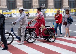 Woman on a bicycle carries a dog