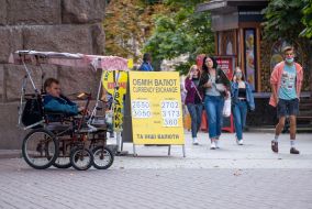 A man in a wheelchair asks for alms