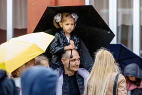 The first-grader holds an umbrella in her hands