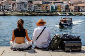 Tourists with suitcases are waiting for a boat on the waterfront