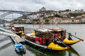 View of excursion boats on the Douro River and the bridge of Don Luis I with the monastery of Serra do Pilar