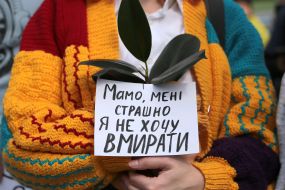 Участница Климатического марша держит плакат