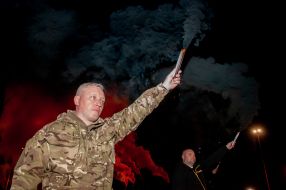 Participant of the March of Defenders of Ukraine holds a firecracker
