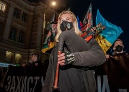 Участник Марша защитников Украины играет на волынке