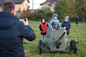 Children are photographed near the cannon