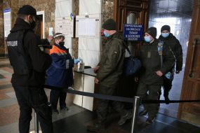 Checking the temperature of passengers with a non-contact thermometer