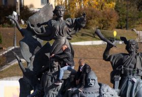 Men at the monument to the founders of Kyiv on Independence Square