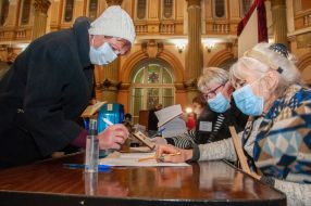 Пожилая женщина получает бюллетень на избирательном участке в Харькове