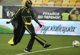 A man in a masquerade costume on a football field