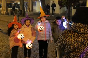 Children in masquerade costumes with pumpkin lanterns