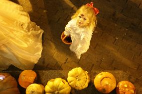 Girl in a masquerade costume with a basket in his hands