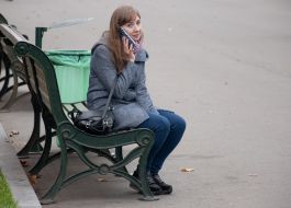 The girl is talking on the phone in the Taras Shevchenko Park