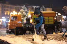 A boy shovels snow on the street in Kiev