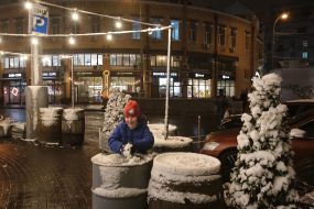 A child sculpts a snowball from the first snow in Kiev