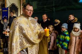 Священностужитель несет зажженную свечу