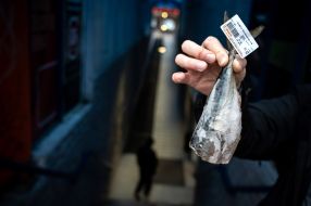 Покупець тримає заморожену рибу в руках