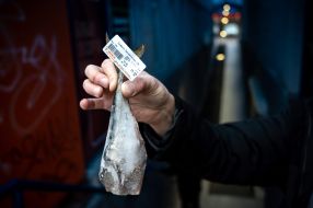 The buyer holds a frozen fish in his hands
