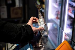 Price tag on the tail of frozen fish