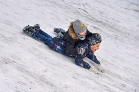 Children play on a snow slide